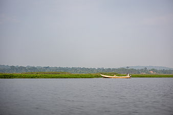 Small wooden boat with fishermen on calm river landscape