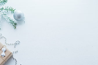Minimalist Christmas Flat Lay with Gift and Ornament on White Wood