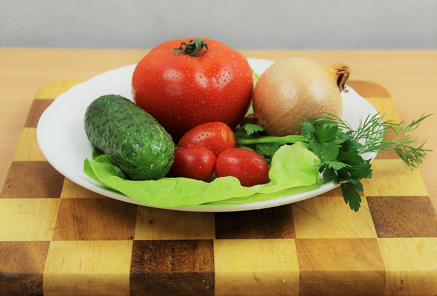 Fresh vegetables on a white plate with water droplets