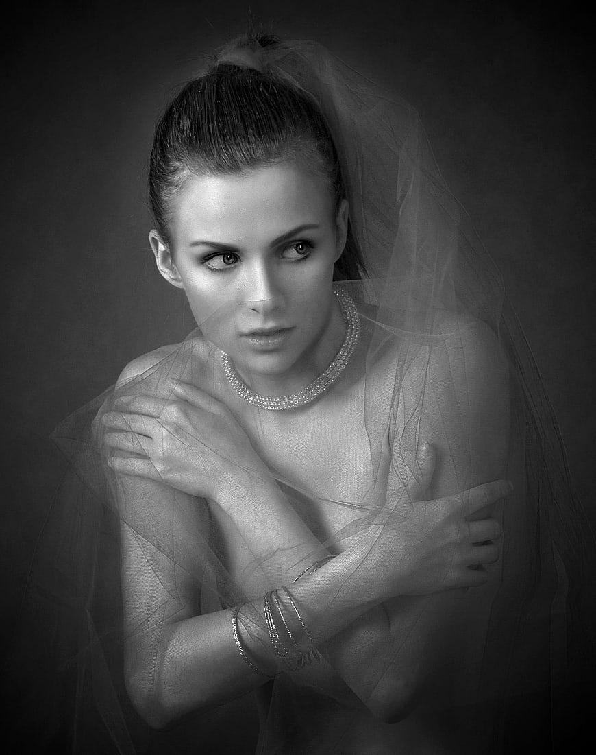 Black and white portrait of a woman with a veil and jewelry