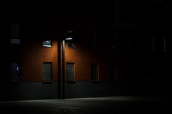 Dark brick building illuminated by street lamp at night