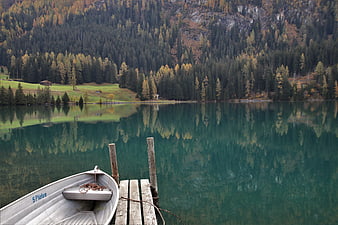 Alpine Lake Reflection With Wooden Boat And Autumn Forest