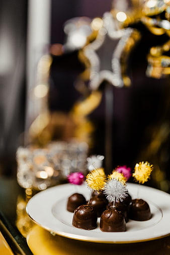 Chocolate truffles with festive tinsel toppers on a white plate