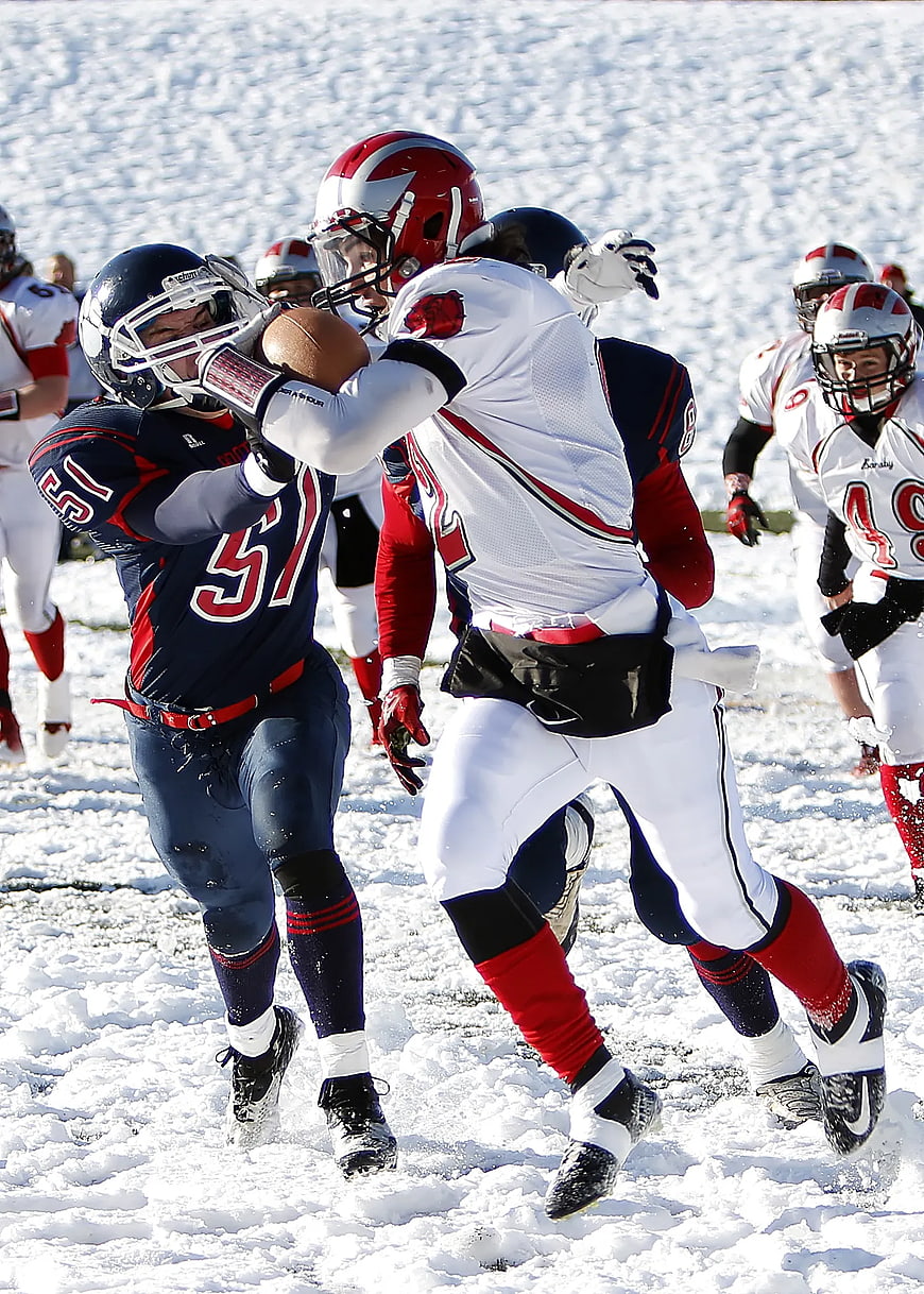 American Football Players Tackling in Snow