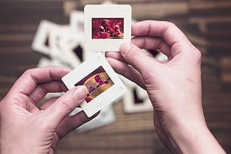 Hands holding vintage film slides with cartoon characters