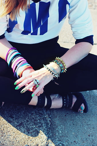 Woman wearing colorful bracelets and skull ring