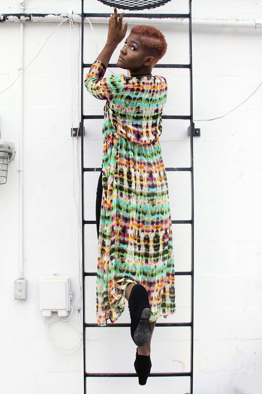 Woman in Colorful Dress Climbing Urban Ladder