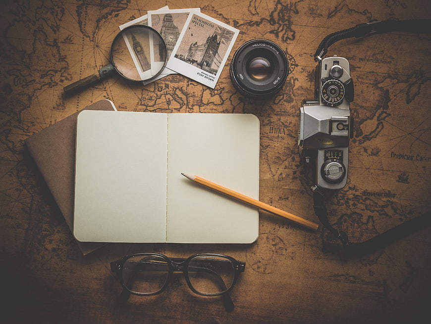 Vintage travel planning flat lay with camera, map, and notebook