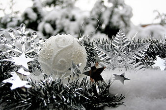 White Christmas Ornaments and Silver Tinsel in Snow