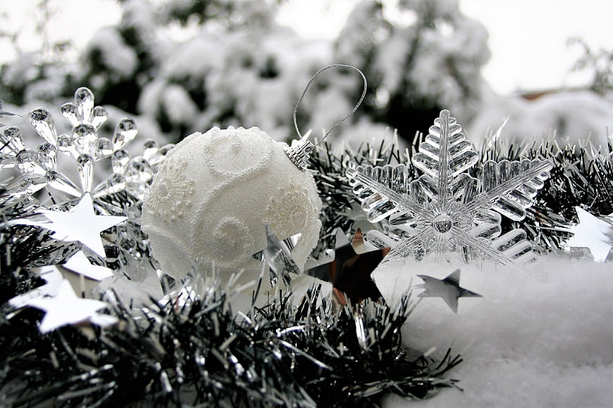 White Christmas Ornaments and Silver Tinsel in Snow
