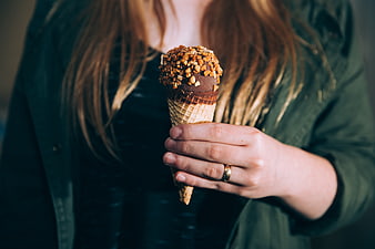 Woman Holding Chocolate Ice Cream Cone with Nuts
