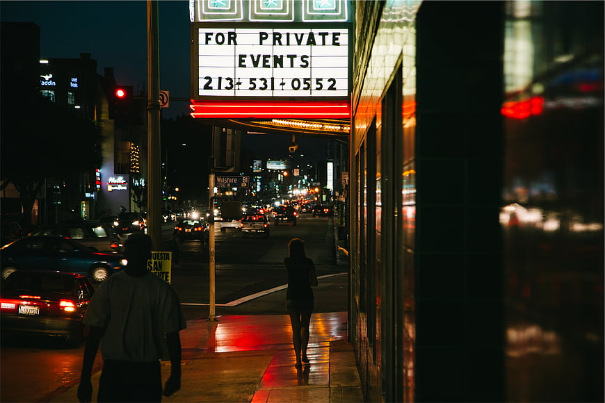 Night street scene with theater marquee and pedestrians