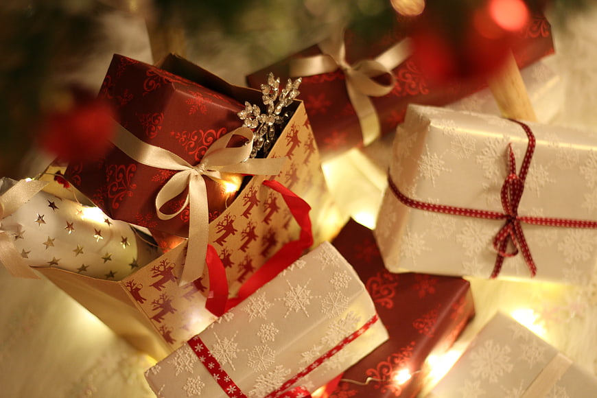 Christmas gifts wrapped in red and white paper with lights