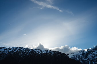 Snow-Capped Mountain Peaks Against a Bright Blue Sky