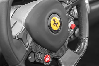 Close-up of Ferrari steering wheel with carbon fiber and engine start button