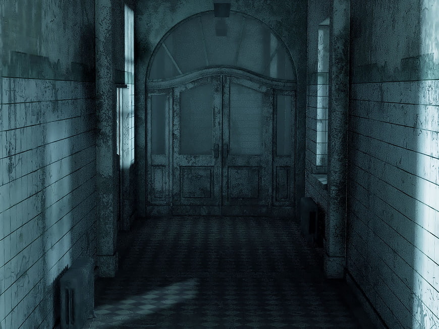 Dark abandoned hallway with weathered double doors