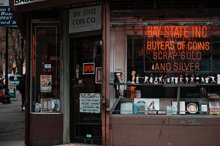 Vintage Coin Shop Exterior with Neon Sign and Collectibles