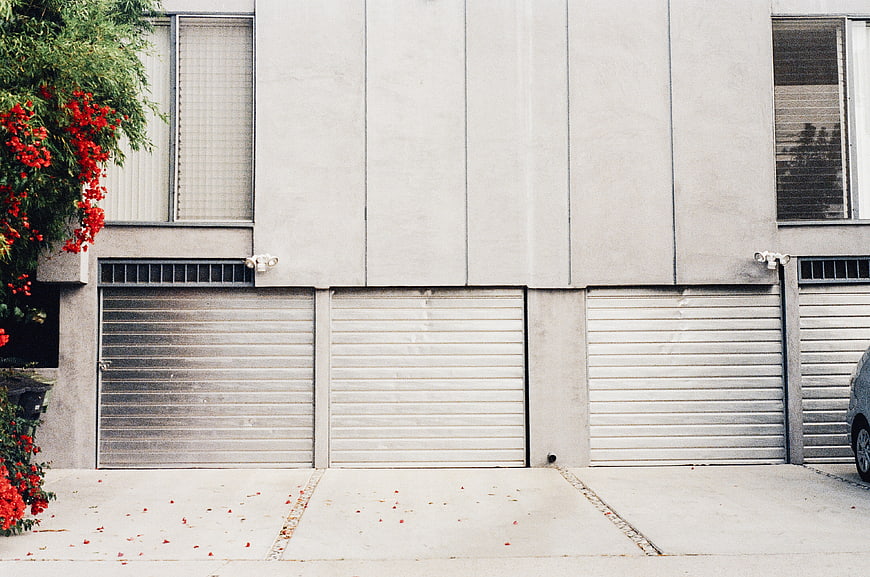 Modern House Facade with Garage Doors and Red Flowers