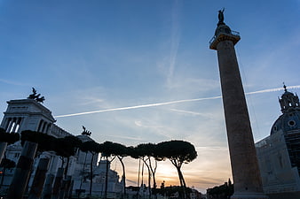Sunset silhouette of Trajan's Column and Altar of the Fatherland in Rome