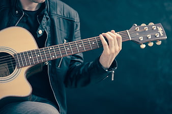 Musician Playing Acoustic Guitar in Leather Jacket