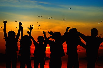Silhouetted Children Celebrating Joyfully at Vibrant Sunset