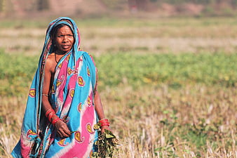 Indian tribal woman in colorful sari standing in field