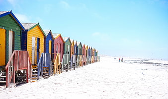 Colorful Beach Huts on White Sand Shoreline