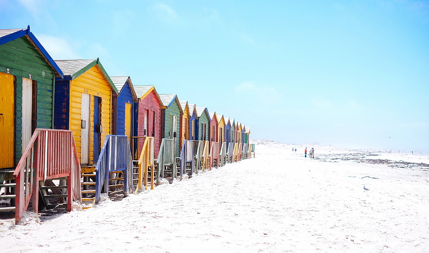 Colorful Beach Huts on White Sand Shoreline