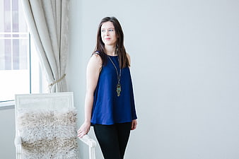 Woman in Blue Top Standing by Window with Copyspace