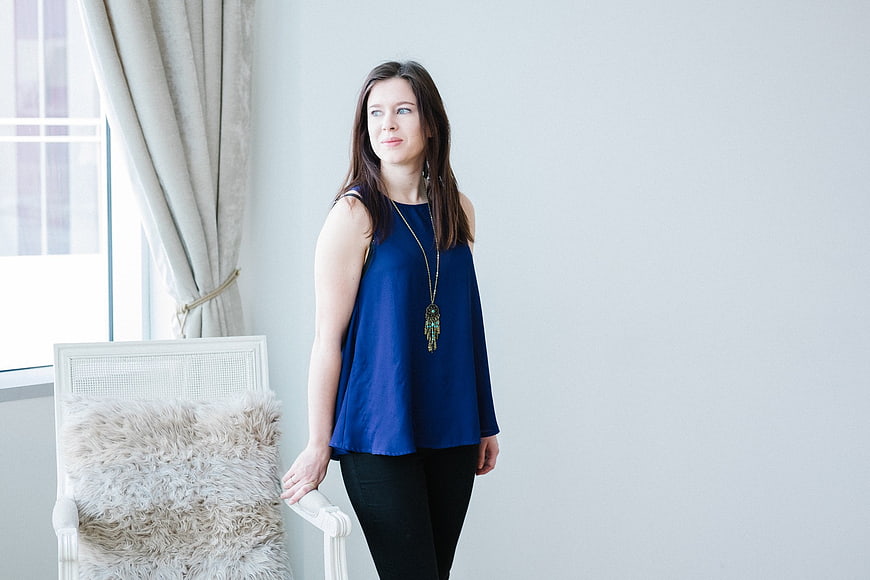 Woman in Blue Top Standing by Window with Copyspace