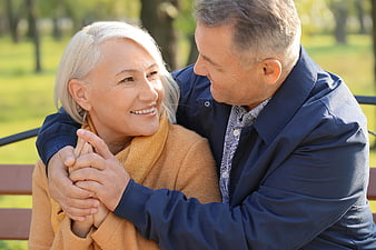 Happy Senior Couple Embracing on Park Bench