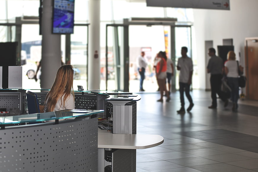 Woman working at reception desk in modern office lobby
