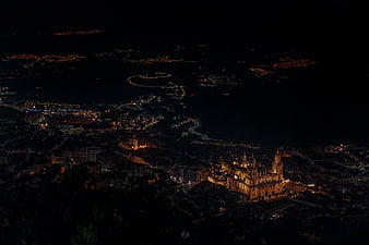 Aerial night view of Seville Cathedral and city lights