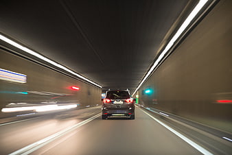 Black SUV driving fast through a tunnel with motion blur
