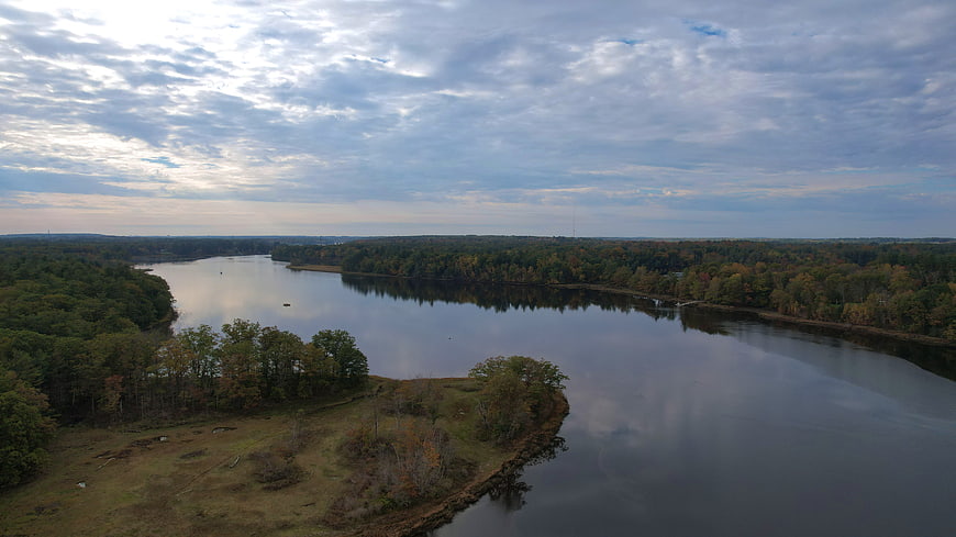 Aerial View of Serene River Winding Through Autumn Forest