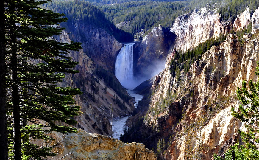 Majestic Waterfall Cascading Through Deep Forested Canyon