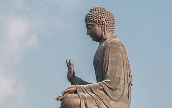 Side Profile of Giant Bronze Buddha Statue Against Blue Sky