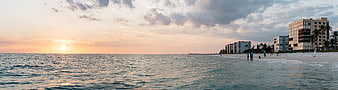 Panoramic Sunset View of Ocean Beach with Hotels and People