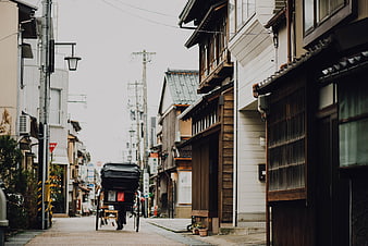 Rickshaw pulling through narrow traditional Japanese street