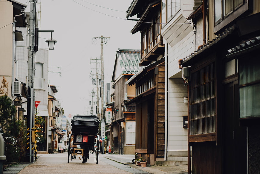 Rickshaw pulling through narrow traditional Japanese street