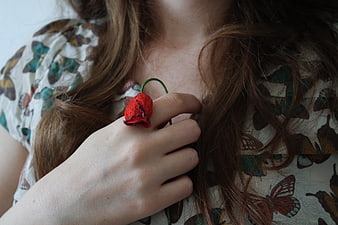 Woman Wearing Red Flower Ring on Butterfly Print Shirt
