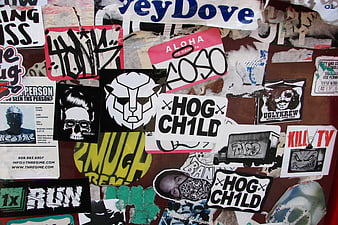 Collage of punk rock stickers and graffiti on a wall