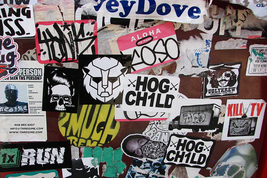 Collage of punk rock stickers and graffiti on a wall