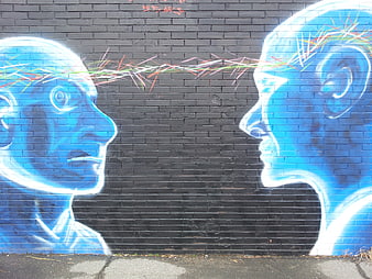 Blue Graffiti Mural of Two Heads Connecting on Brick Wall