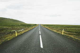 Empty asphalt road stretching through green rural landscape