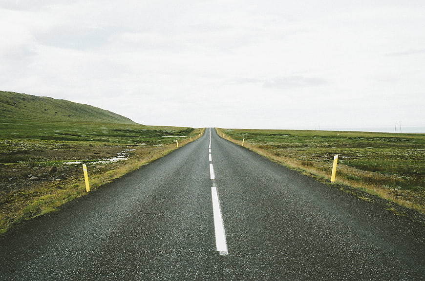 Empty asphalt road stretching through green rural landscape
