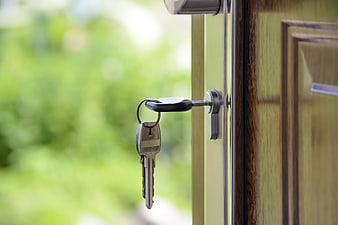 Keys in Door Lock with Blurred Green Background