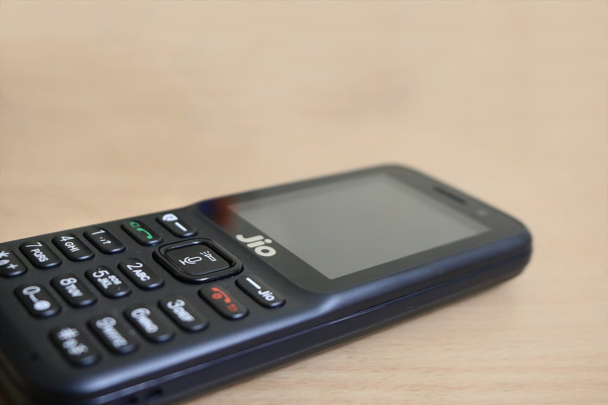 Black Jio feature phone on wooden table