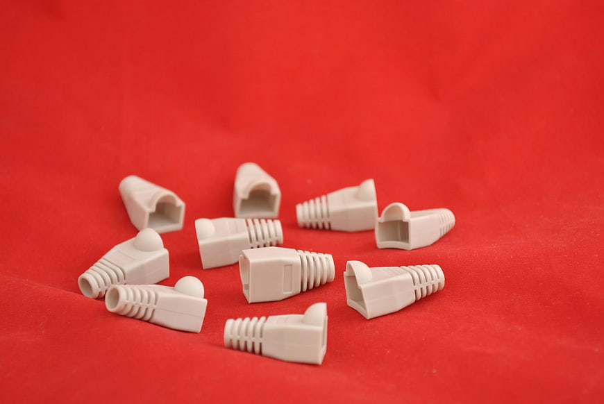 White RJ45 Ethernet Boot Strain Reliefs on Red Background
