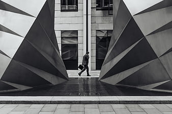 Businessman walking between modern geometric sculptures